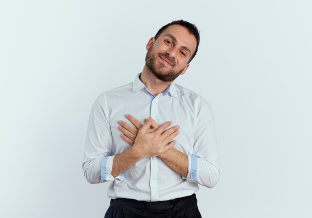 Pleased handsome man puts hands on chest isolated on white wall