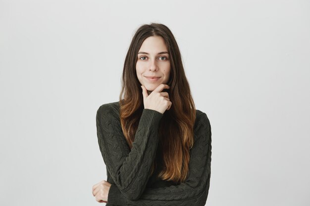 Pleased and intrigued young woman listen good idea