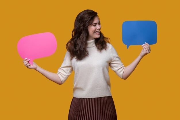 Pleased lady looking at two colorful cardboard tablets