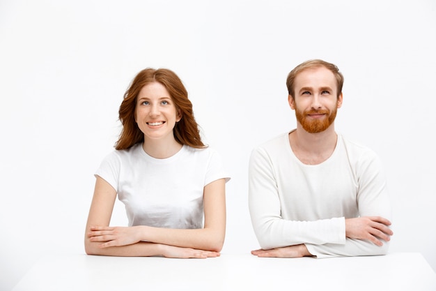 Pleased man and woman, both redheads look up