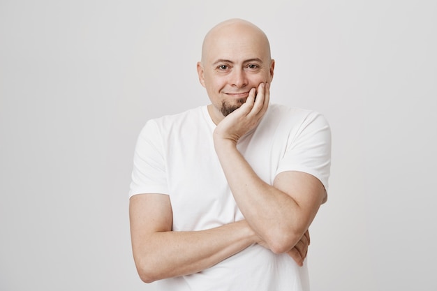 Pleased middle-aged bald man looking with satisfaction, smiling