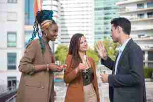 Free photo pleased people at business party on terrace roof. man and women in formal clothes drinking champagne, talking, eating appetizers. teambuilding, party concept