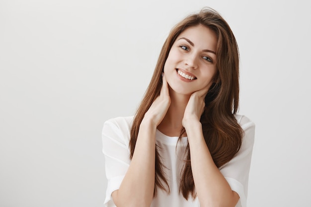 Pleased relaxed woman touching neck and smiling, got rid of pain