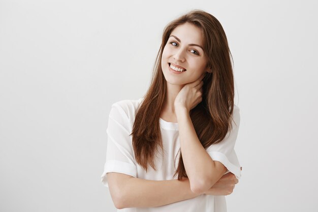 Pleased relaxed woman touching neck and smiling, got rid of pain