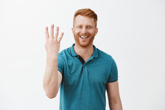 pleased and satisfied male redhead client with bristle in green polo shirt showing number four with fingers and smiling broadly