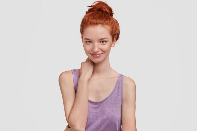 Pleased satisfied young female athlete with ginger hair bun