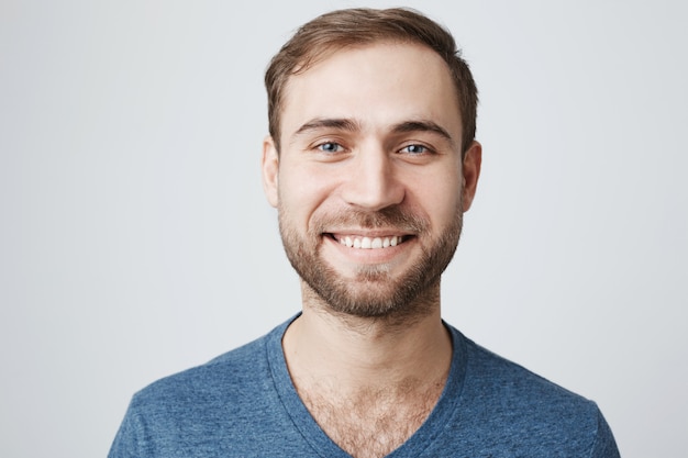 Foto gratuita uomo sorridente piacevole con la barba che guarda macchina fotografica