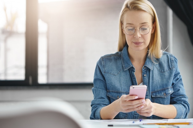 Free photo pleased successful female administrator in office