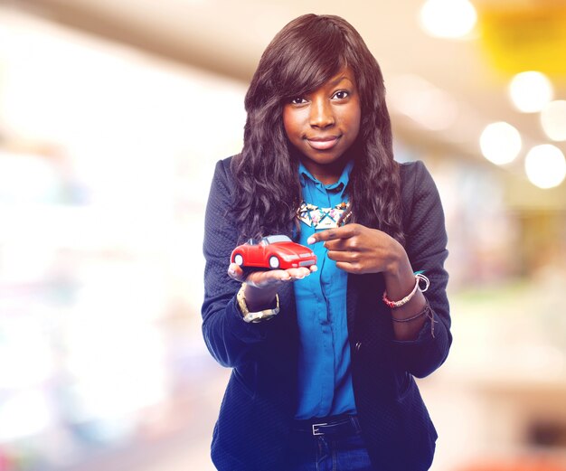 Pleased woman showing a small car on her hand