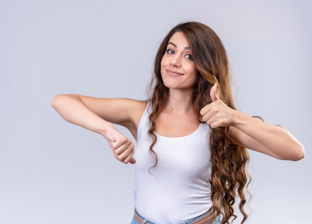 Pleased young beautiful girl showing thumbs up and down 