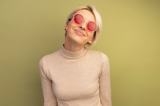 Pleased young blonde girl wearing sunglasses 