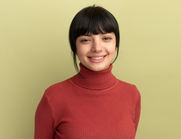 Pleased young brunette caucasian girl looks at camera