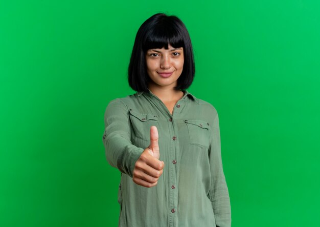 Pleased young brunette caucasian girl thumbs up 
