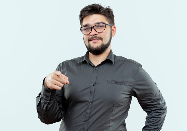 Pleased young businessman wearing glasses showing you gesture isolated on white background