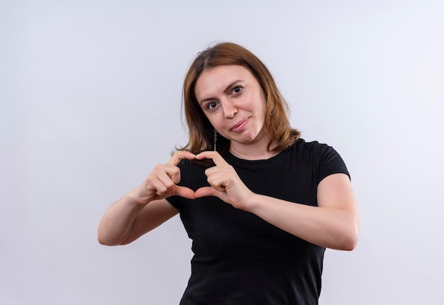 Pleased young casual woman doing heart sign on isolated white space