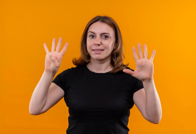 Pleased young casual woman showing four and five on isolated orange space