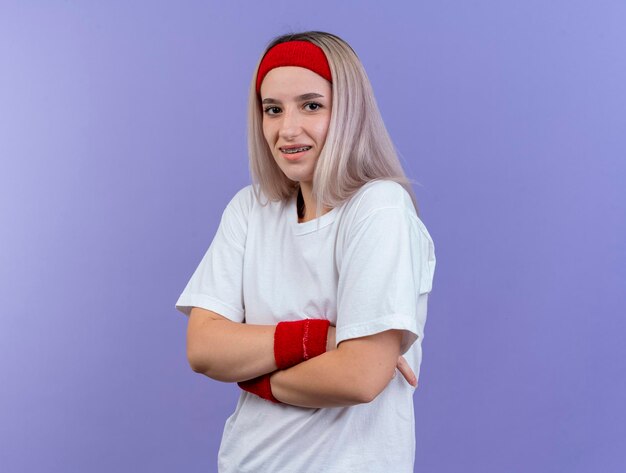 Pleased young caucasian sporty girl with braces wearing headband