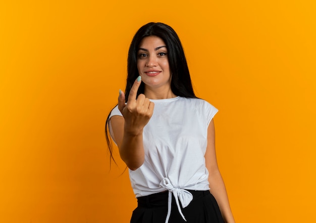 Pleased young caucasian woman gestures come here with finger