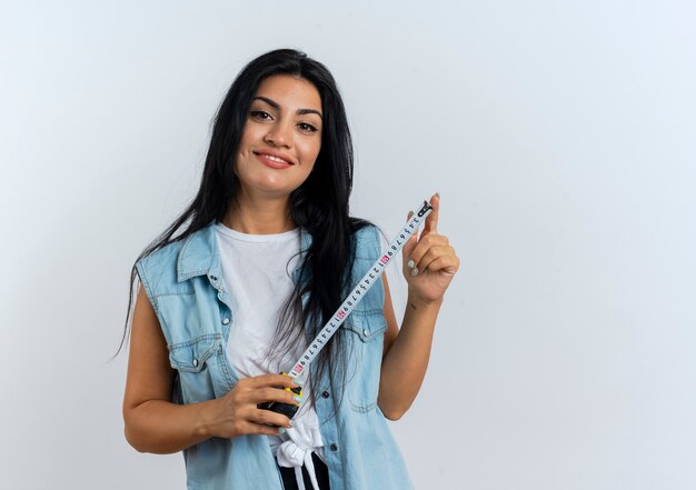 Pleased young caucasian woman holds tape measure