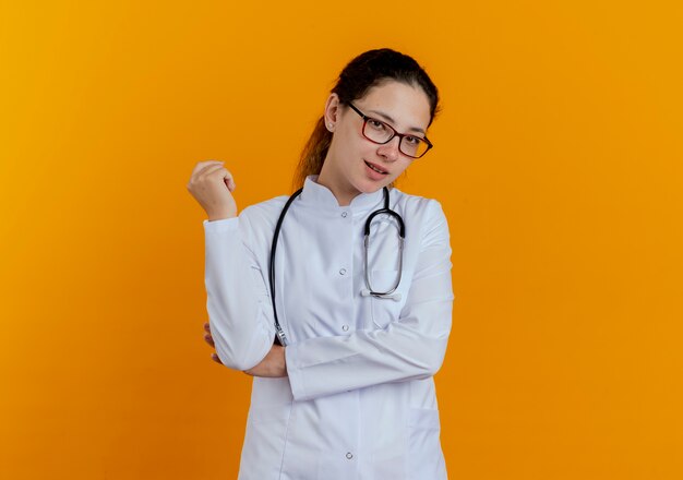 分離された眼鏡と医療ローブと聴診器を身に着けている若い女性医師を喜ばせる
