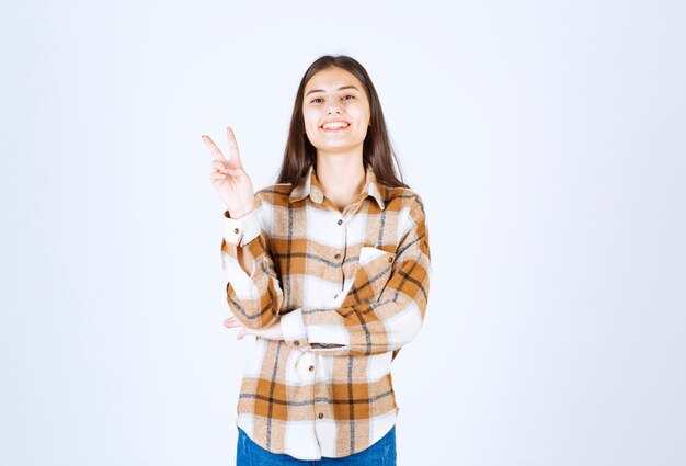 pleased young girl model showing victory sign . 