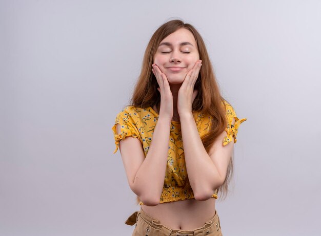 Pleased young girl putting hands on cheeks with closed eyes  with copy space