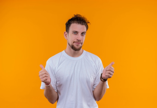 Pleased young guy wearing white t-shirt his thumbs up on isolated orange background