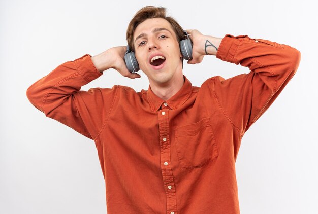 Pleased young handsome guy wearing red shirt with headphones 