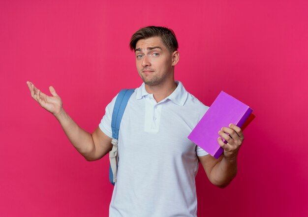 Soddisfatto giovane studente maschio bello che porta i libri della holding della borsa posteriore