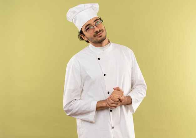 pleased young male cook wearing chef uniform and glasses showing handshakes 