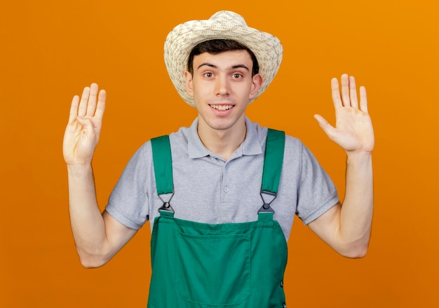 Free photo pleased young male gardener wearing gardening hat gestures nine with fingers