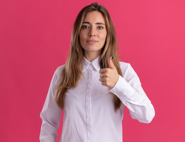 Pleased young pretty caucasian girl thumbs up isolated on pink wall with copy space