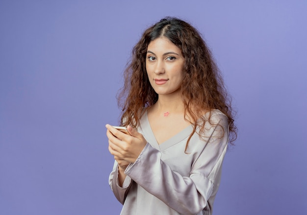 pleased young pretty girl holding phone 