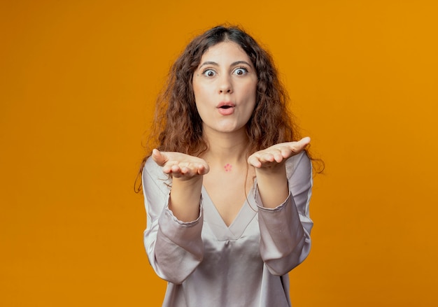 Pleased young pretty girl showing kiss gesture isolated on yellow