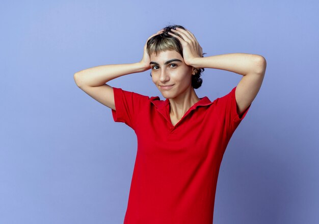 pleased young woman with pixie haircut holding head