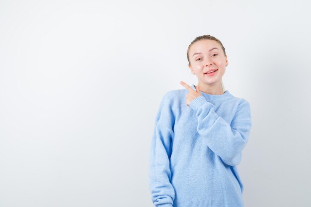 Pleasent girl is showing her finger on white background