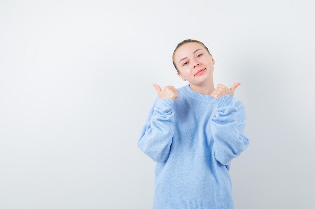 Pleasent girl is showing her thumbs on white background