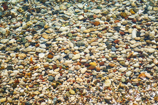 海岸上のカラフルな小石のプレンティ