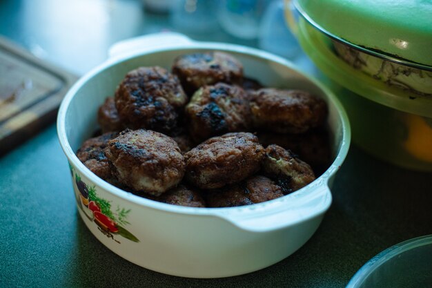 Free photo plenty of ready-made fried meatballs lie in a large white aluminum pan on the table