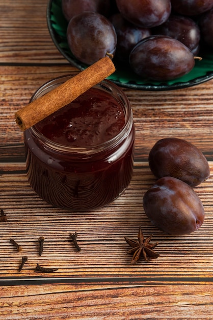 Plum confiture in a glass jar with spices.