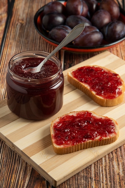 Plum confiture in glass jars with toast breads.