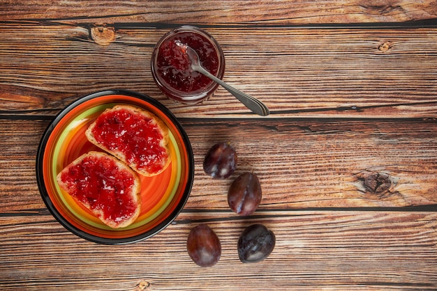 Plum confiture in glass jars with toast breads.