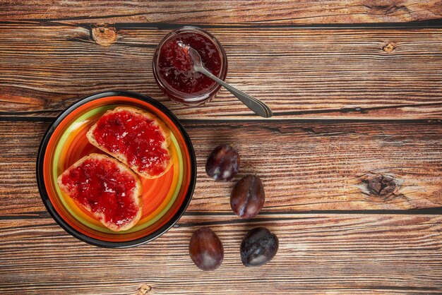 Plum confiture in glass jars with toast breads.