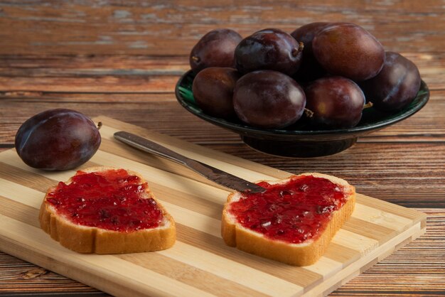 Plum confiture on toast breads and fruits.