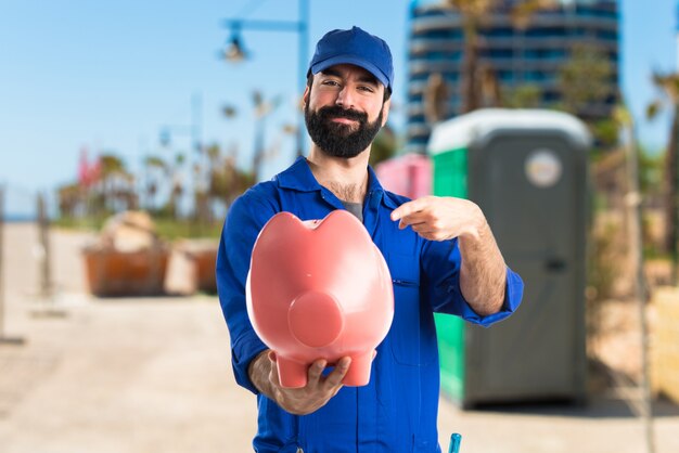 Plumber holding a piggybank