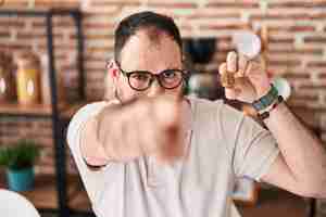 Free photo plus size hispanic man with beard holding virtual currency bitcoin pointing with finger to the camera and to you confident gesture looking serious