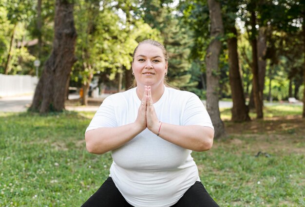 Plus size model doing exercises in park