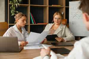 Free photo plus-size woman business woman working with colleagues in a professional office