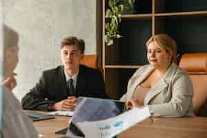 Free photo plus-size woman business woman working with colleagues in a professional office