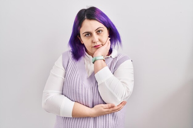 Plus size woman wit purple hair standing over white background thinking looking tired and bored with depression problems with crossed arms.